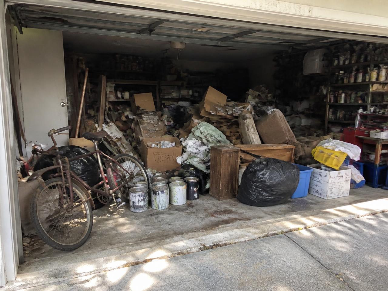 Cluttered two-car garage packed with junk before removal